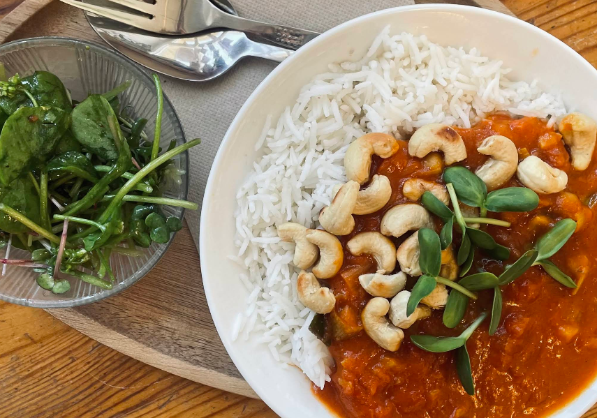 Warmes saisonales Mittagsgericht mit Reis, Curry und Cashews